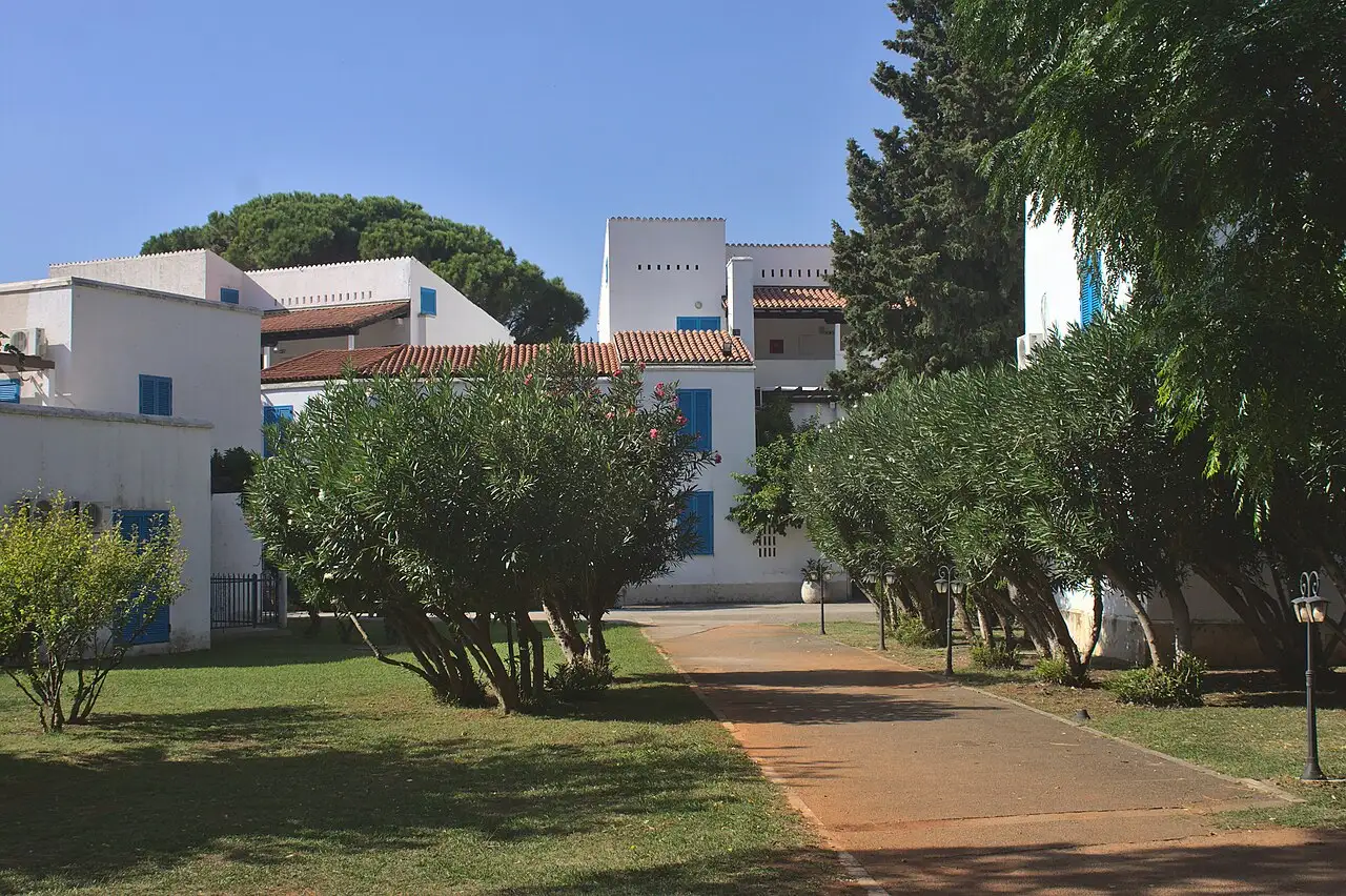 Whitewashed villa buildings and gardens at the Slovenska Plaža hotel complex in Budva