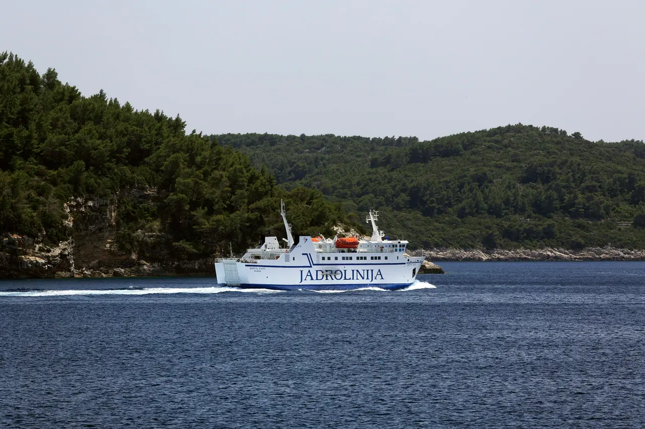 The Jadrolinija ferry Bartol Kasic under way past a wooded Adriatic shoreline