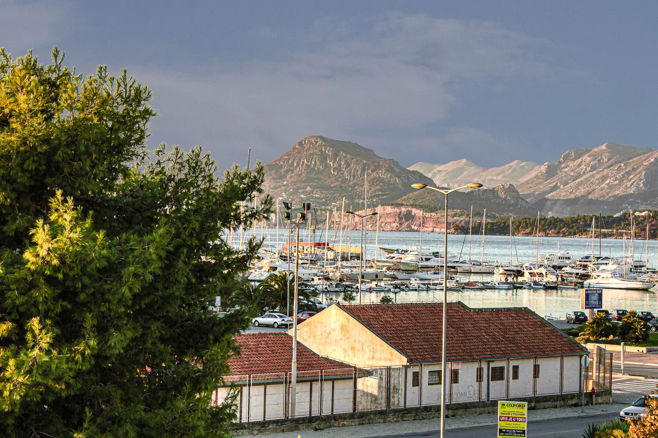 The harbour at Bar, Montenegro, with moored yachts, the coastal road and the mountains of the hinterland behind