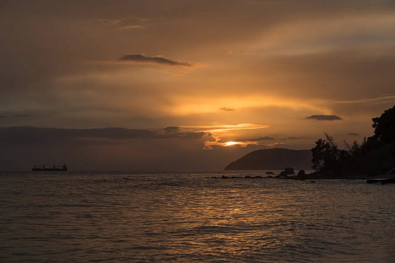 A golden Adriatic sunset with a cargo ship silhouette seen from Šušanj beach near Bar