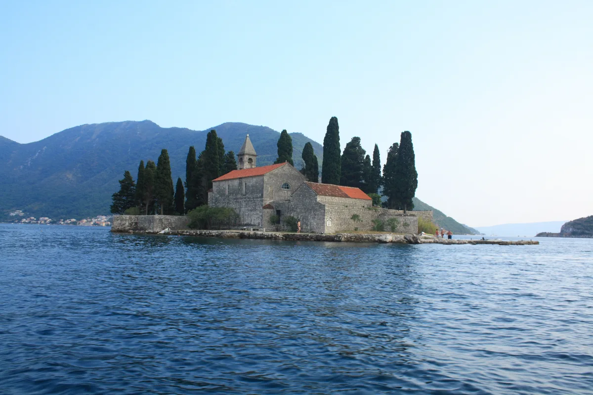 Wide view over the Bay of Kotor, steep green mountains meeting deep blue water