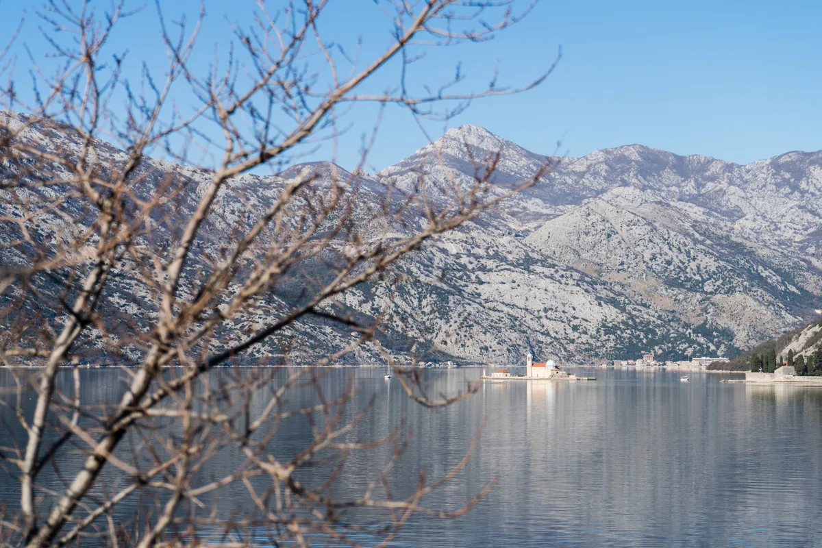 Our Lady of the Rocks island and its blue-domed church seen across the water of the Bay of Kotor