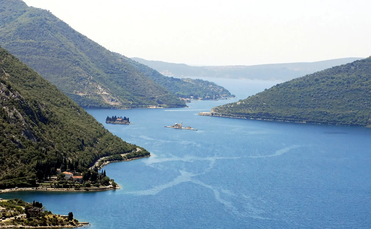 View down the Bay of Kotor toward the Verige Strait from the hills above Risan, with the two Perast islands in the water