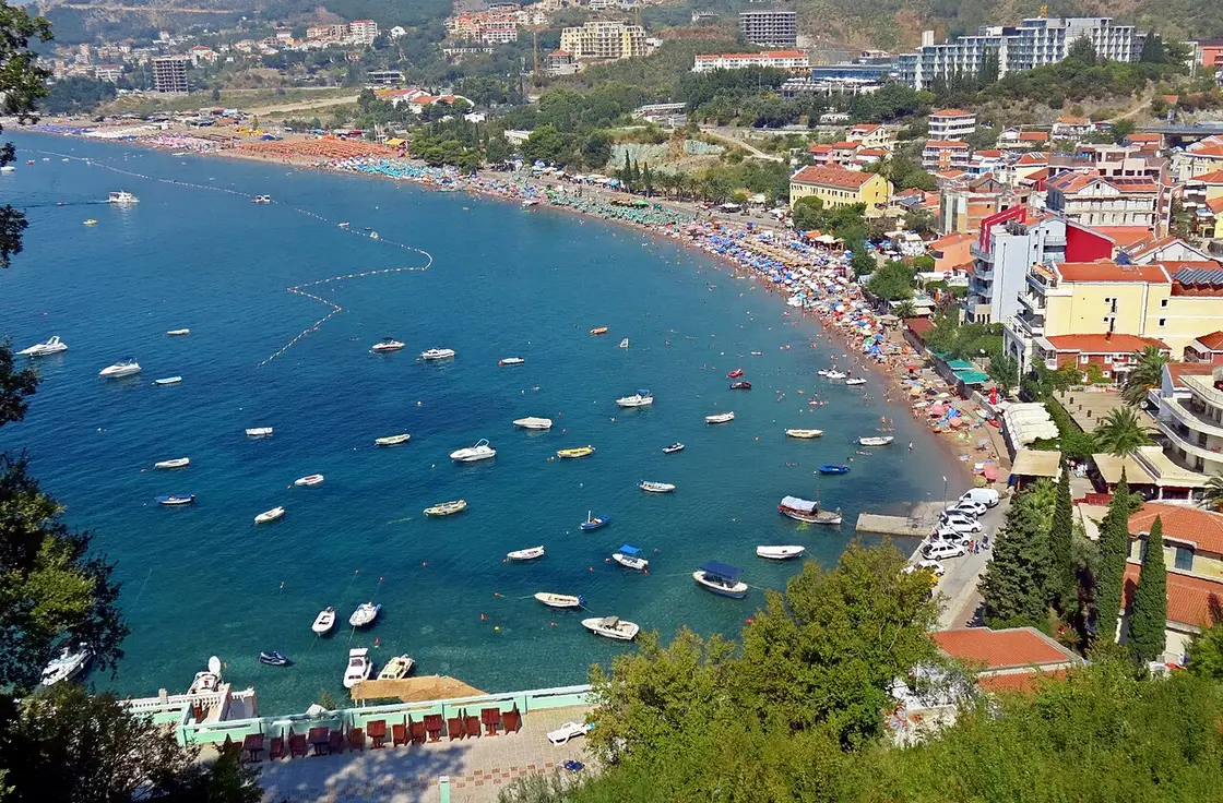 Wide view over the Bečići bay with mountains rising behind the resort strip