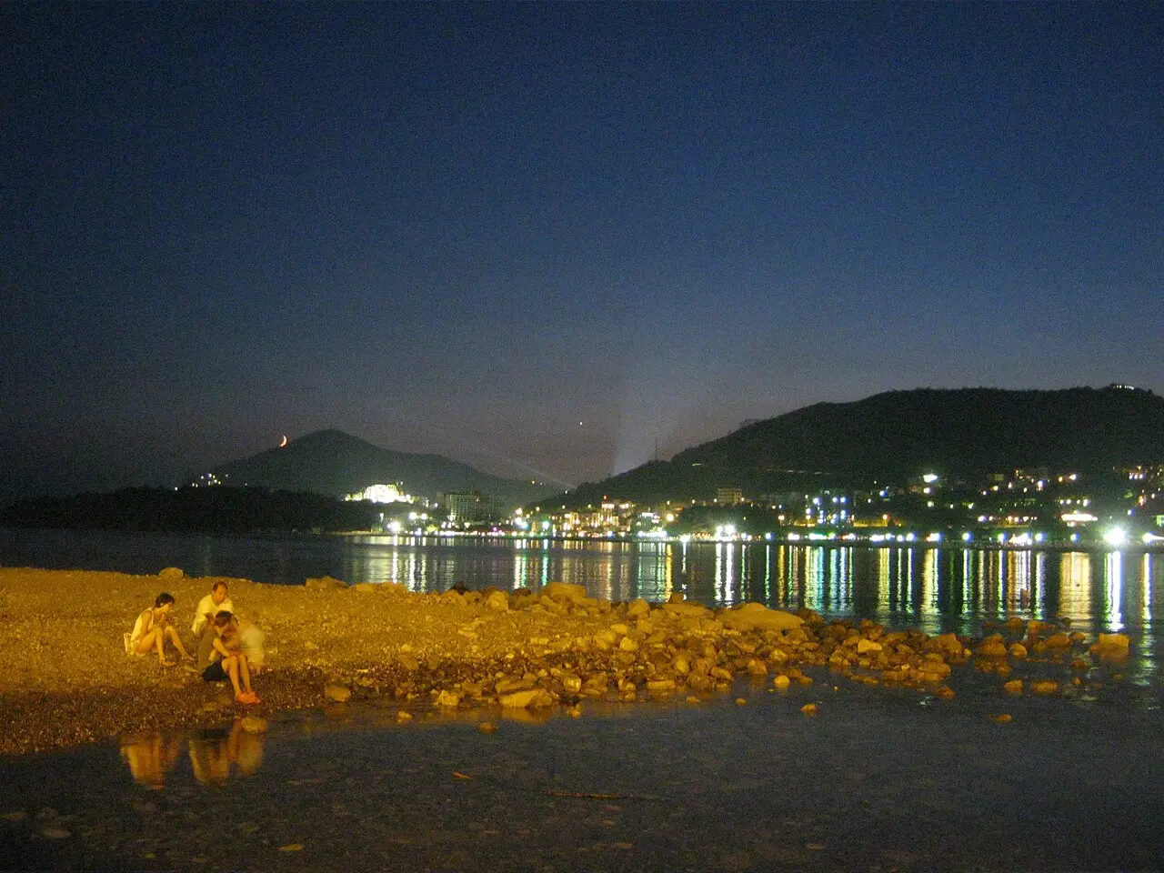 Crowded Bečići beach in July with swimmers and sunbeds packed along the shore