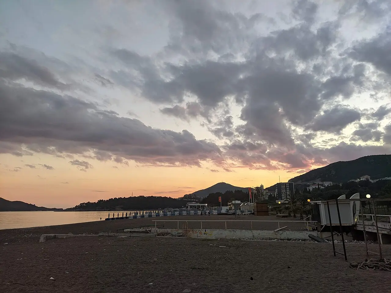 Empty sun loungers and folded umbrellas on Bečići beach in the shoulder season