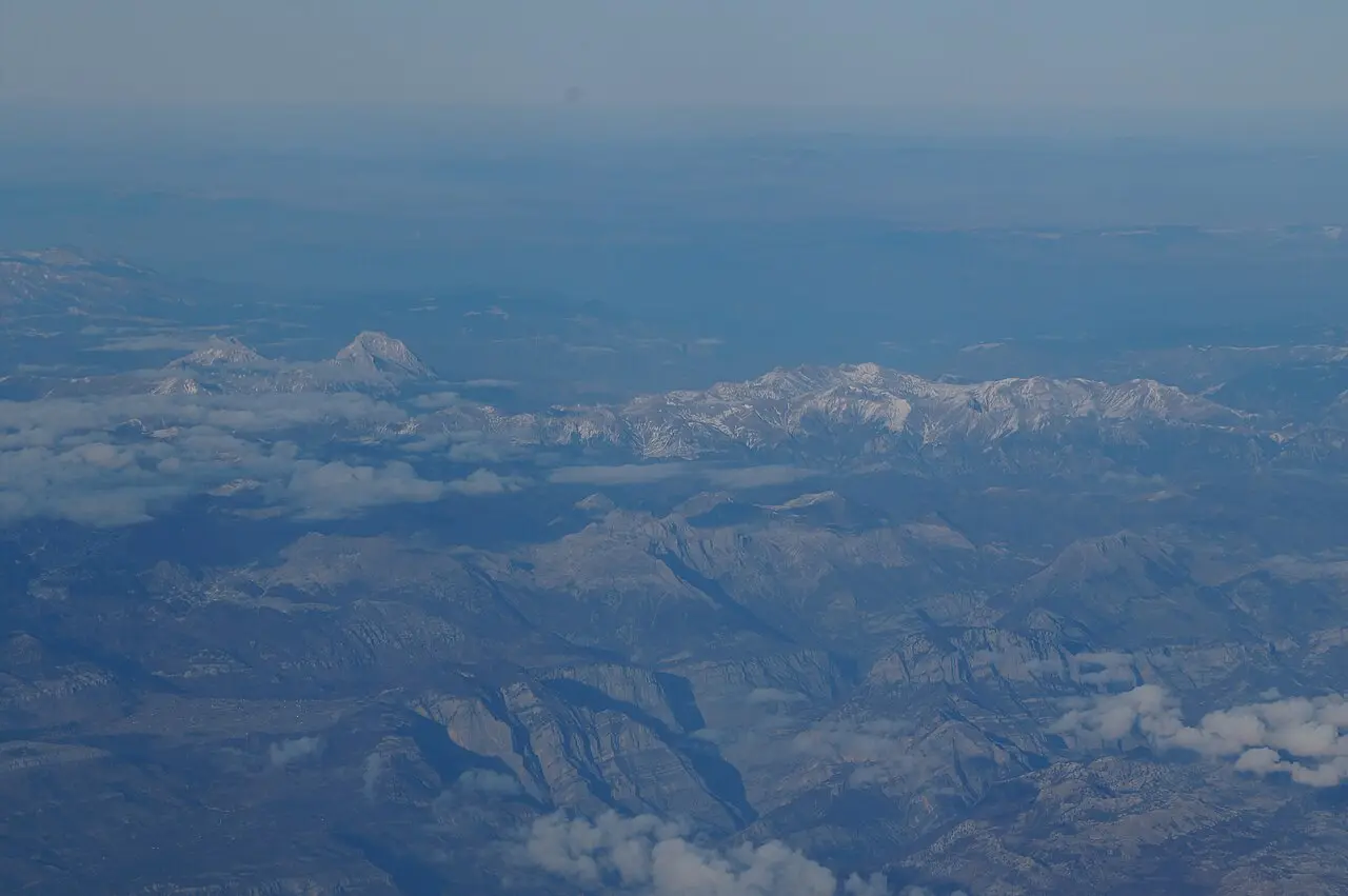 Rolling green mountains of the Komovi range in eastern Montenegro under a clear sky