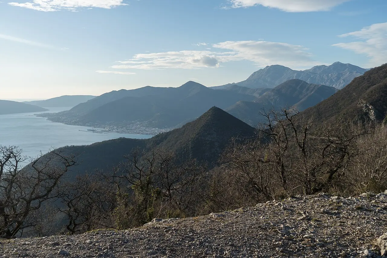 A stony hiking trail on Vrmac peninsula above the Bay of Kotor with mountains in the distance