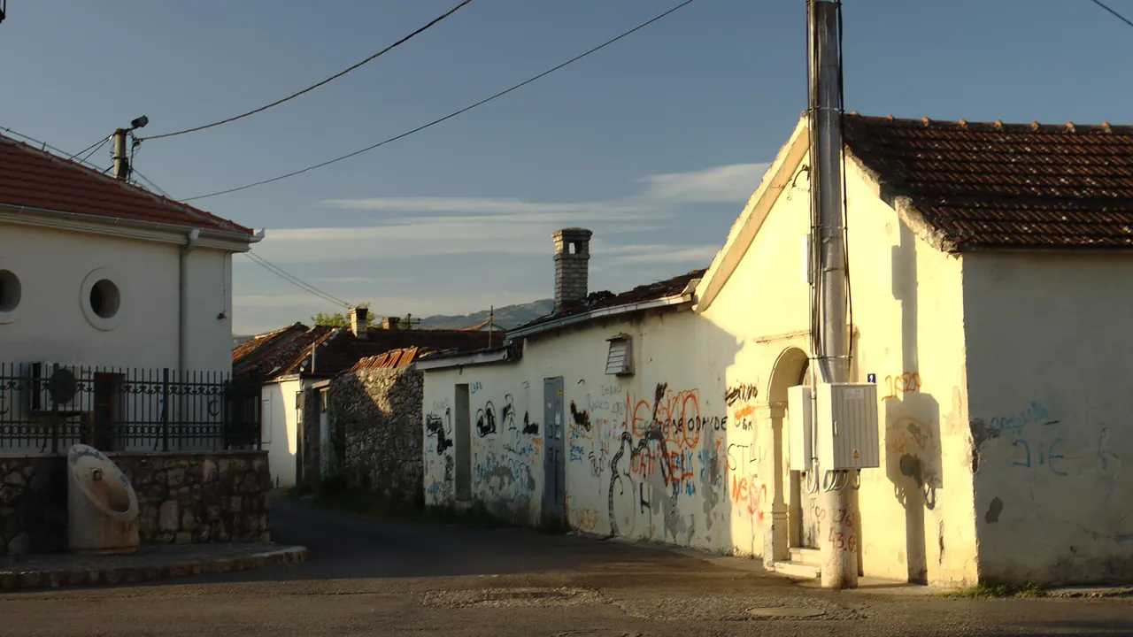 Stone houses and a quiet street in Podgorica old town under a clear sky