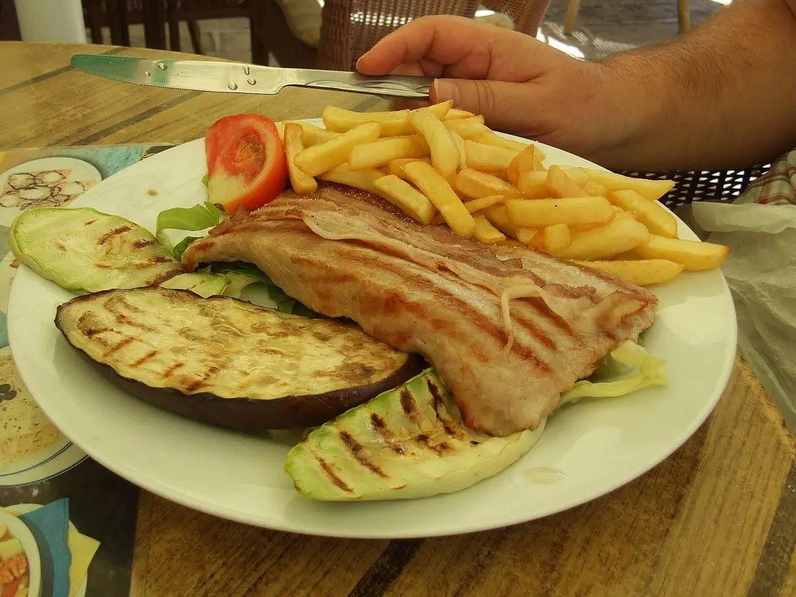 Njeguški steak with fries and salad on a restaurant plate