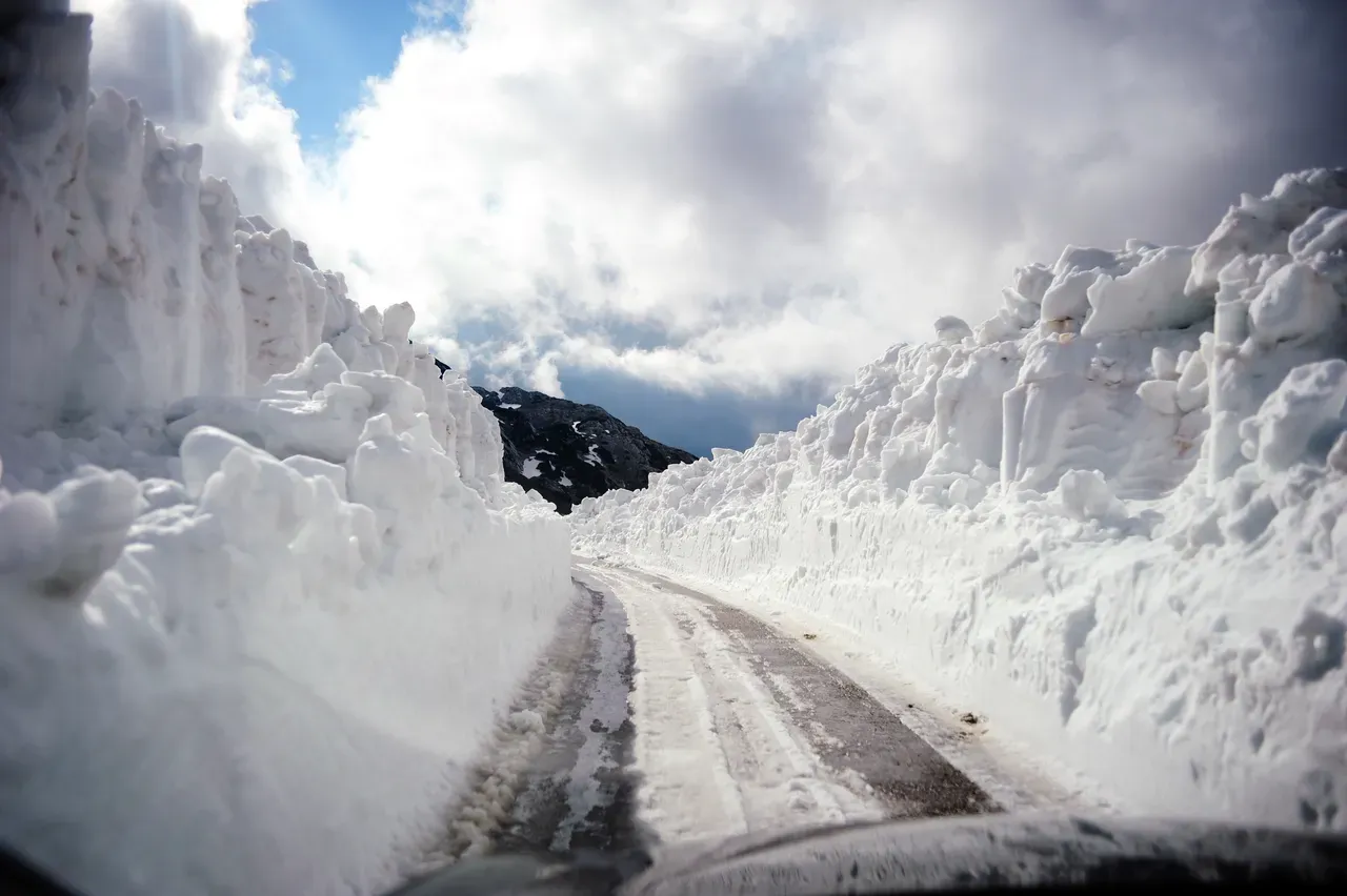 Snow-covered mountain road winding through the Durmitor range in winter, Montenegro