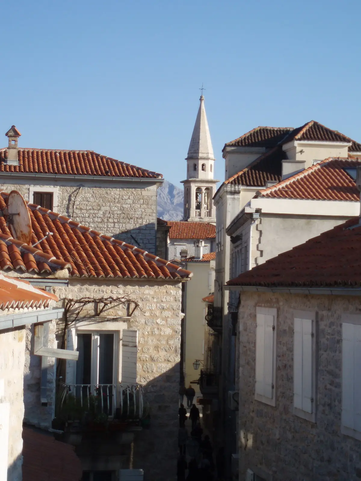 Narrow lane and bell tower of Budva's Old Town seen from the walls in the shoulder-season quiet, Montenegro
