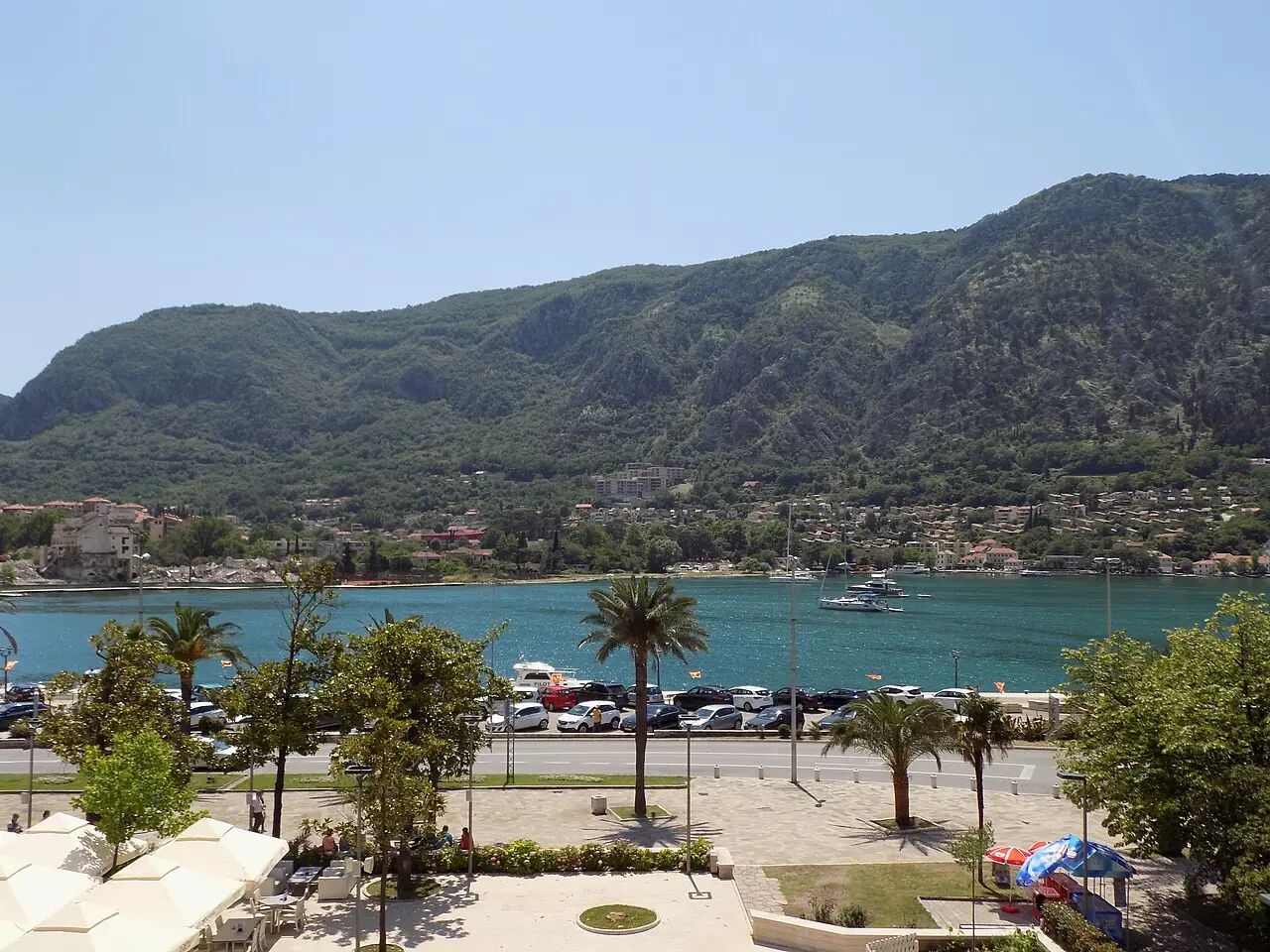 Waterfront promenade outside Kotor Old Town gate with boats on the bay