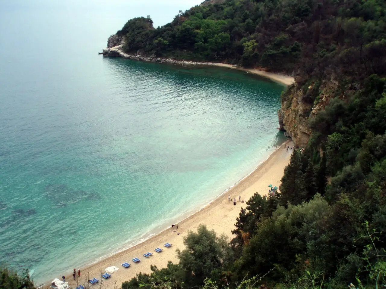 Mogren beach, a small sandy cove below wooded cliffs just outside Budva Old Town