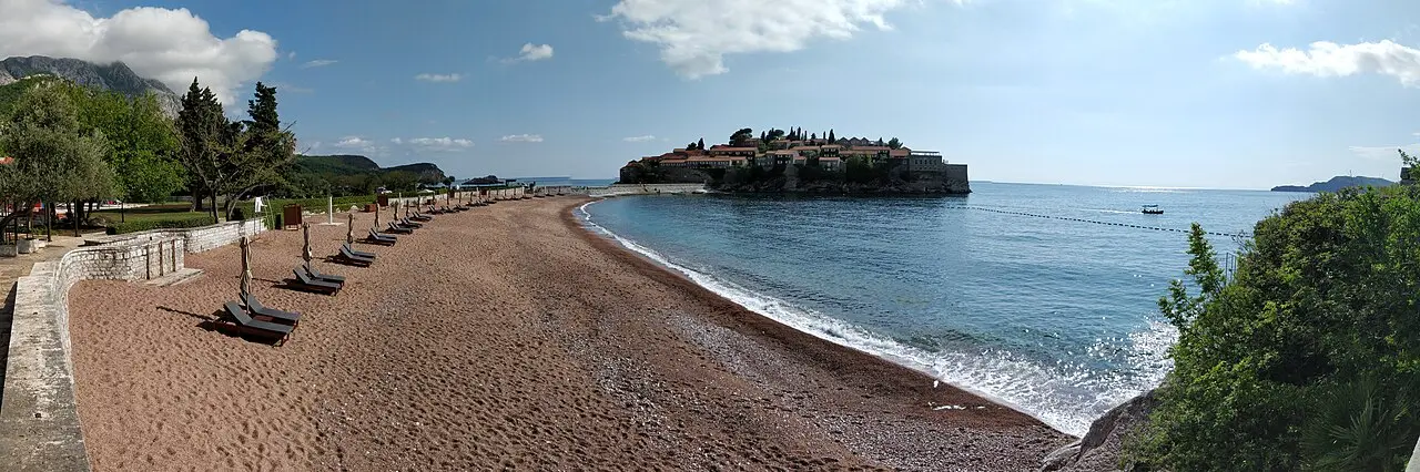 Wide view of the beach and clear water beside the Sveti Stefan causeway near Budva