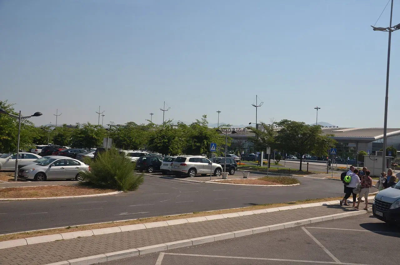 The terminal apron of Podgorica Airport with an aircraft parked outside the arrivals building