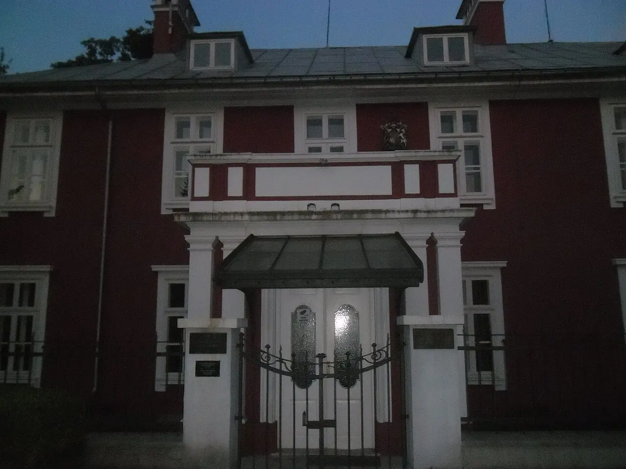 The former British Legation in Cetinje, a red-and-white mansion with a coat of arms above the door