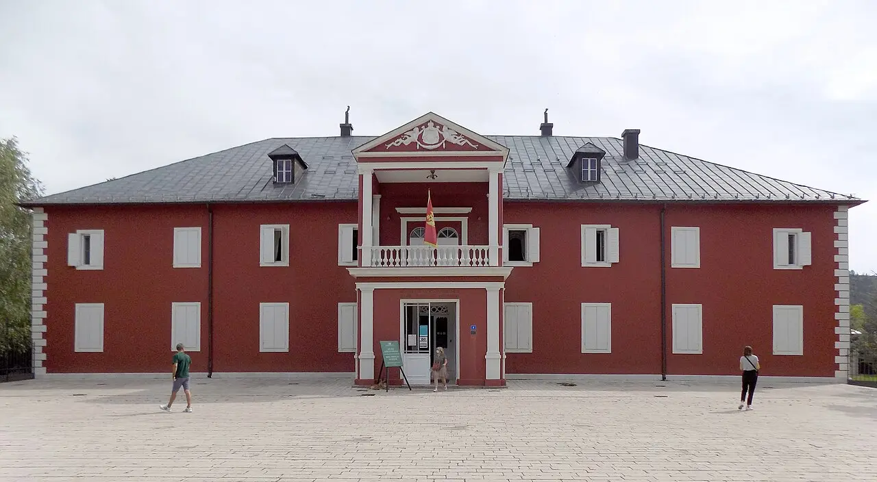 The dark-red facade of King Nikola's Palace, the Court Museum, in Cetinje with a white portico