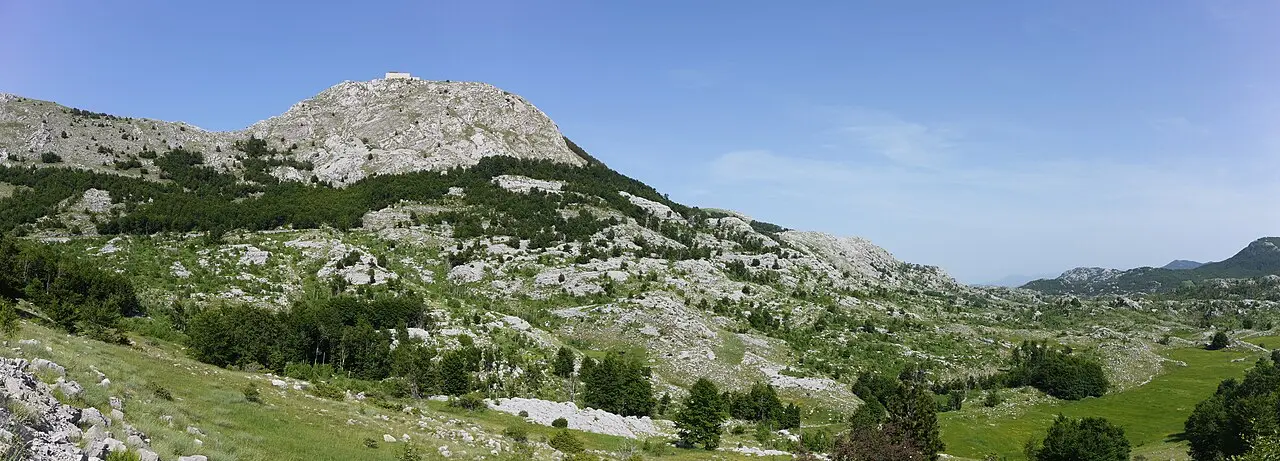 The peak of Jezerski Vrh on Mount Lovćen with the Njegoš Mausoleum on top, above forests and karst
