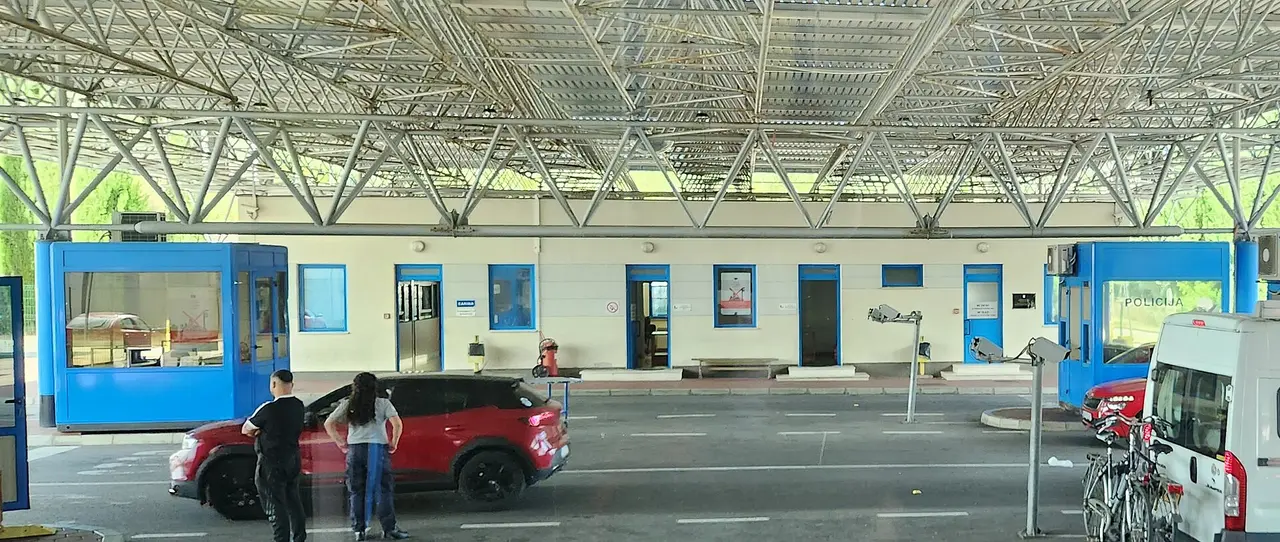 Passport control booths and waiting cars at a road border crossing between Croatia and Montenegro