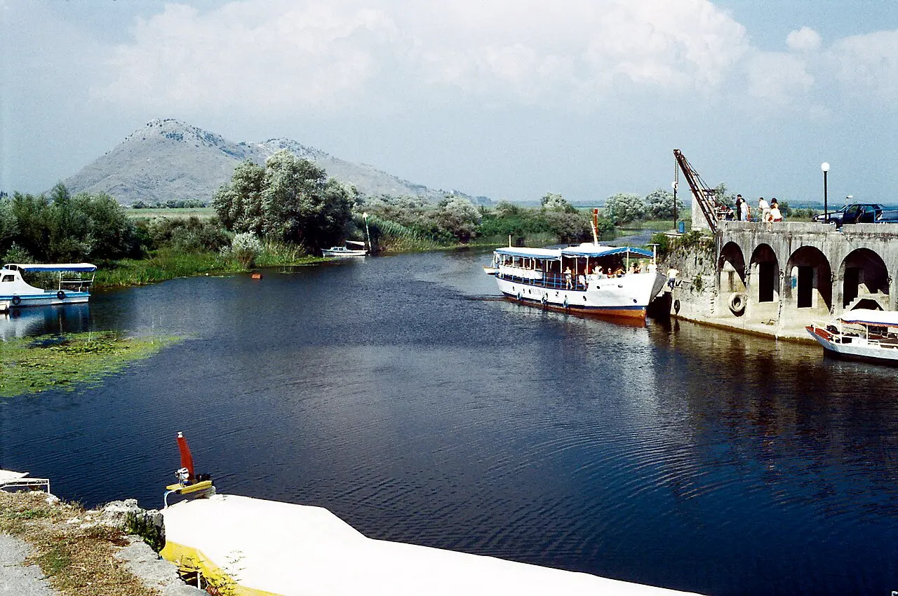 A tour boat moored beside the old stone bridge at Virpazar on Lake Skadar