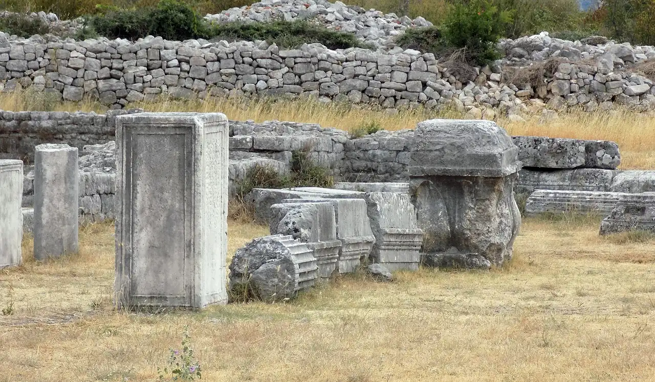 Low stone walls and column drums of the Roman city of Doclea in grass north of Podgorica