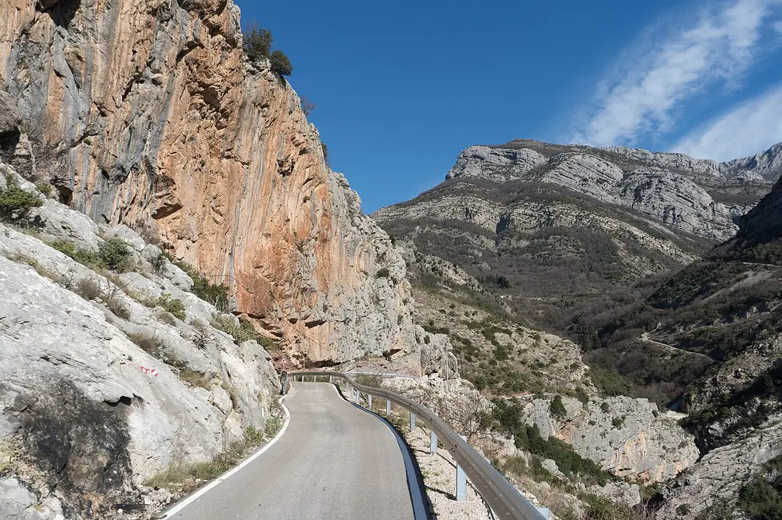 Single-lane asphalt road winding up the dry hills above Stari Bar, southern Montenegro
