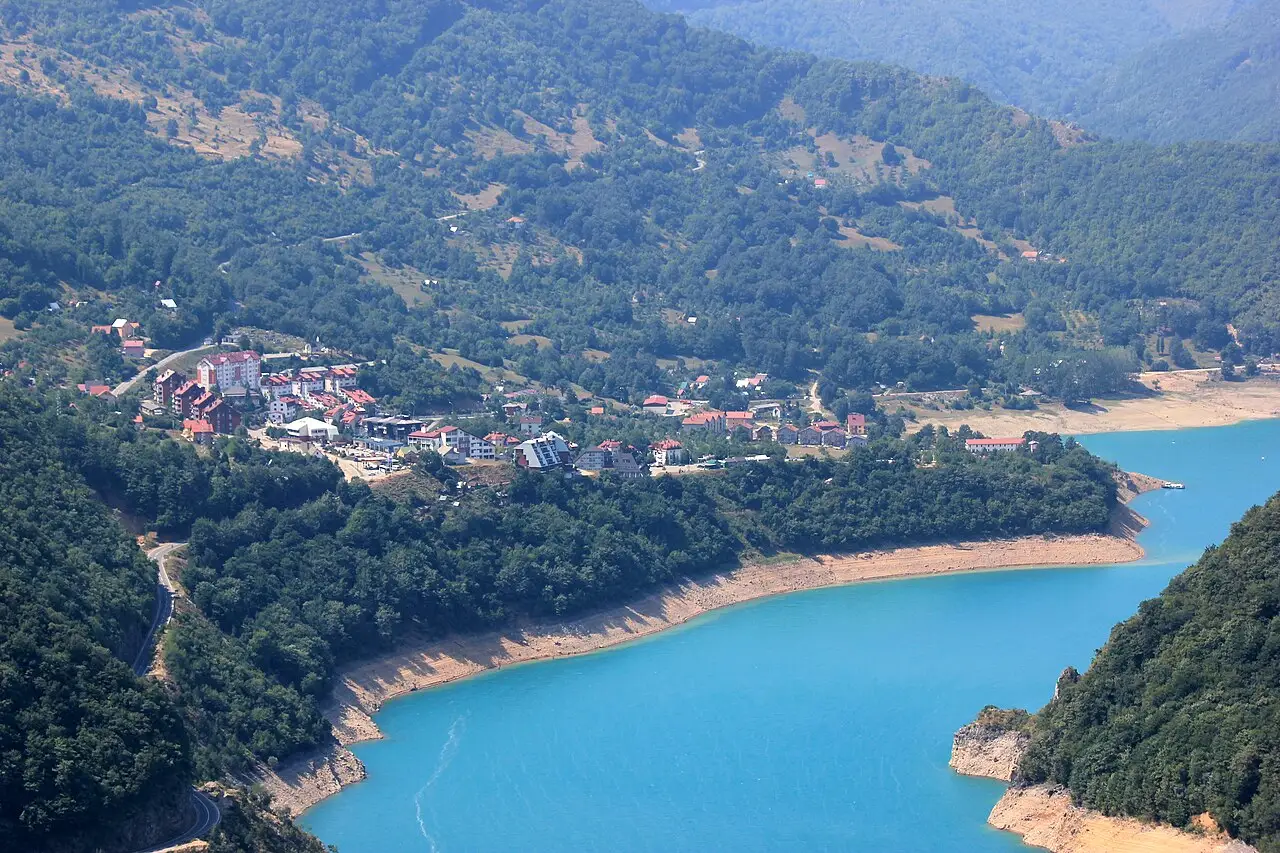 The turquoise Piva reservoir and the town of Plužine seen from the mountain road above