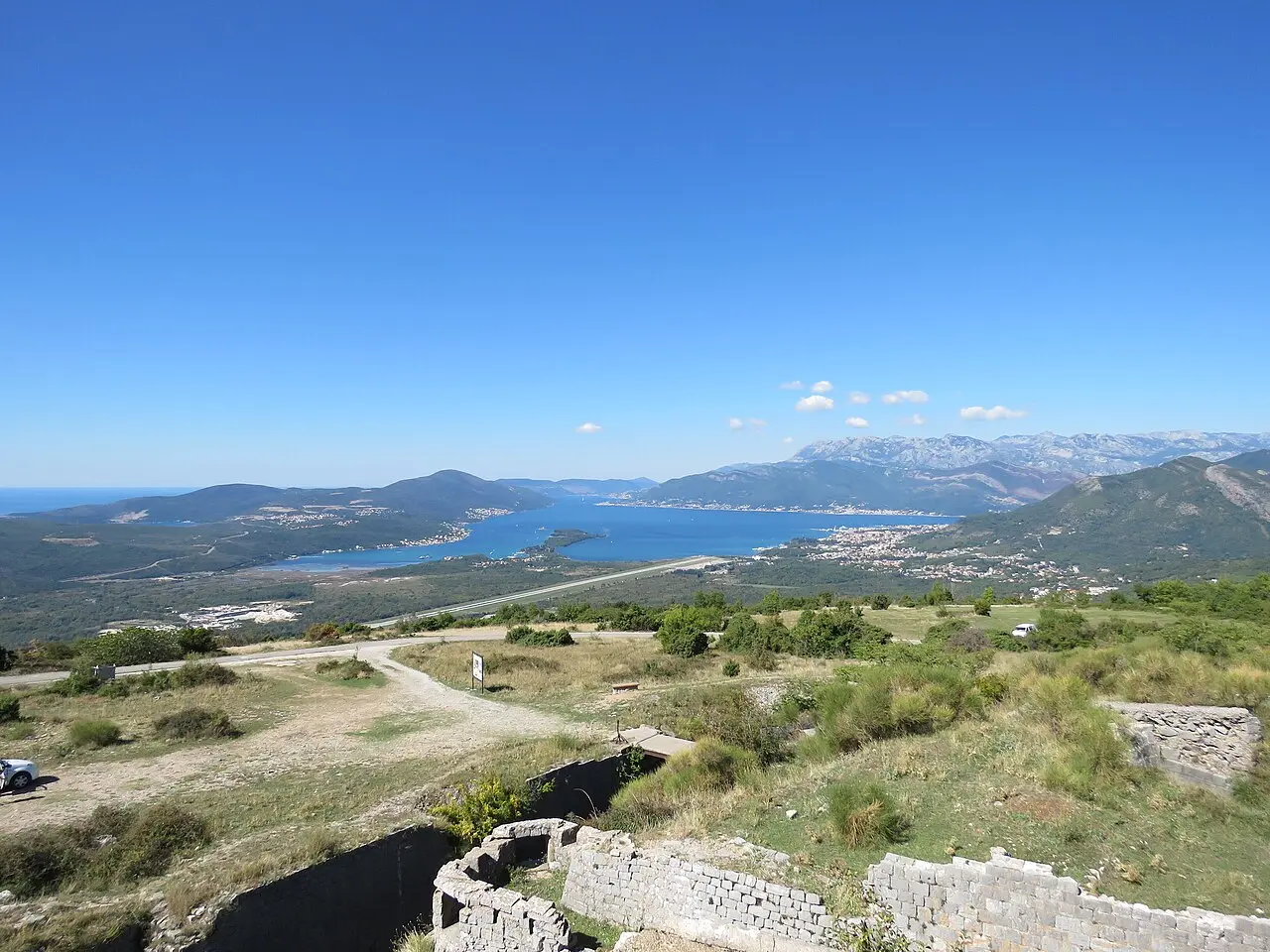 The runway of Tivat Airport on the shore of Tivat Bay, with the mountains of the Bay of Kotor beyond