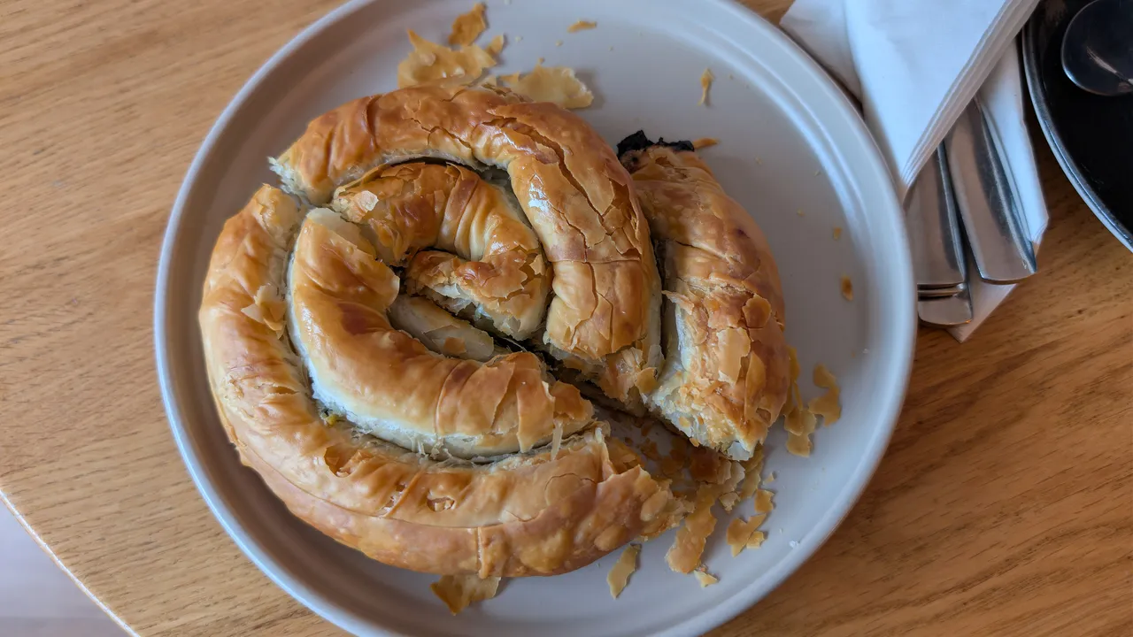 Golden coiled phyllo pie on a plate, a classic of Balkan bakeries