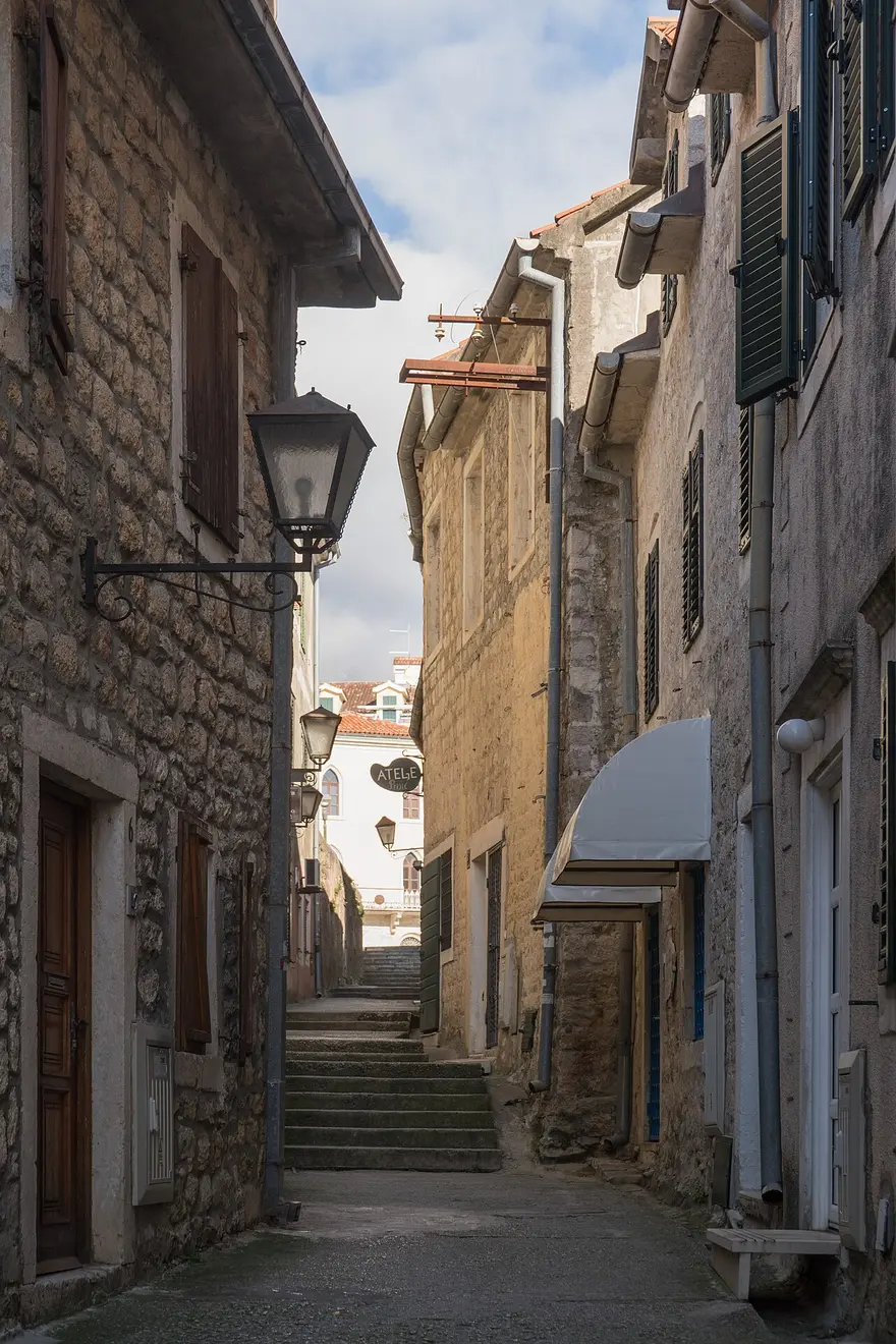 A quiet stone lane with steps and a wrought-iron lamp in the Old Town of Herceg Novi