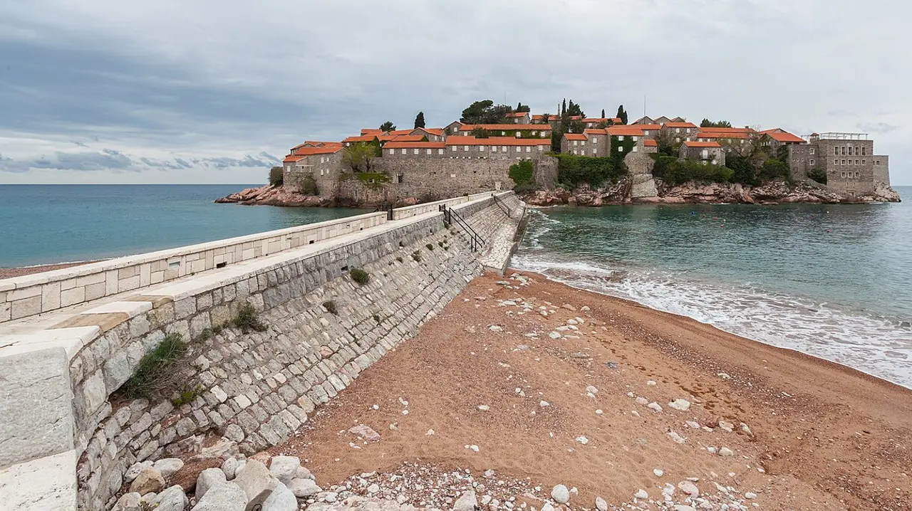 Sveti Stefan islet and its beach on the Budva Riviera, a fortified village on a rocky peninsula linked to the mainland