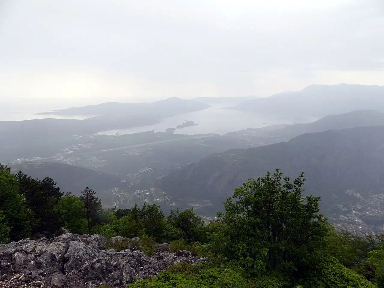 Panoramic view along the Bay of Kotor with mountains and villages under a blue sky
