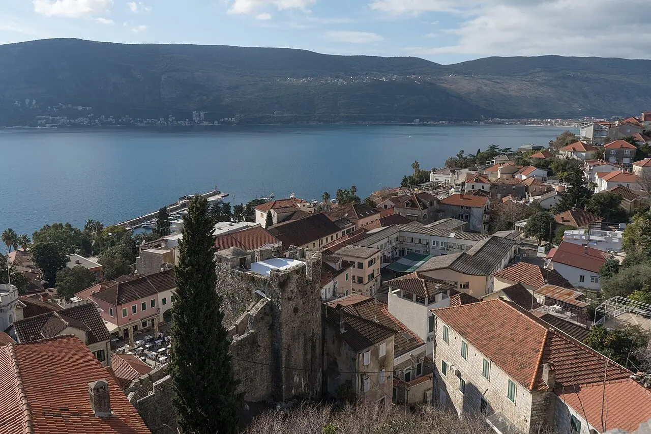 View over the terracotta roofs of Herceg Novi old town to the sunlit mouth of the Bay of Kotor