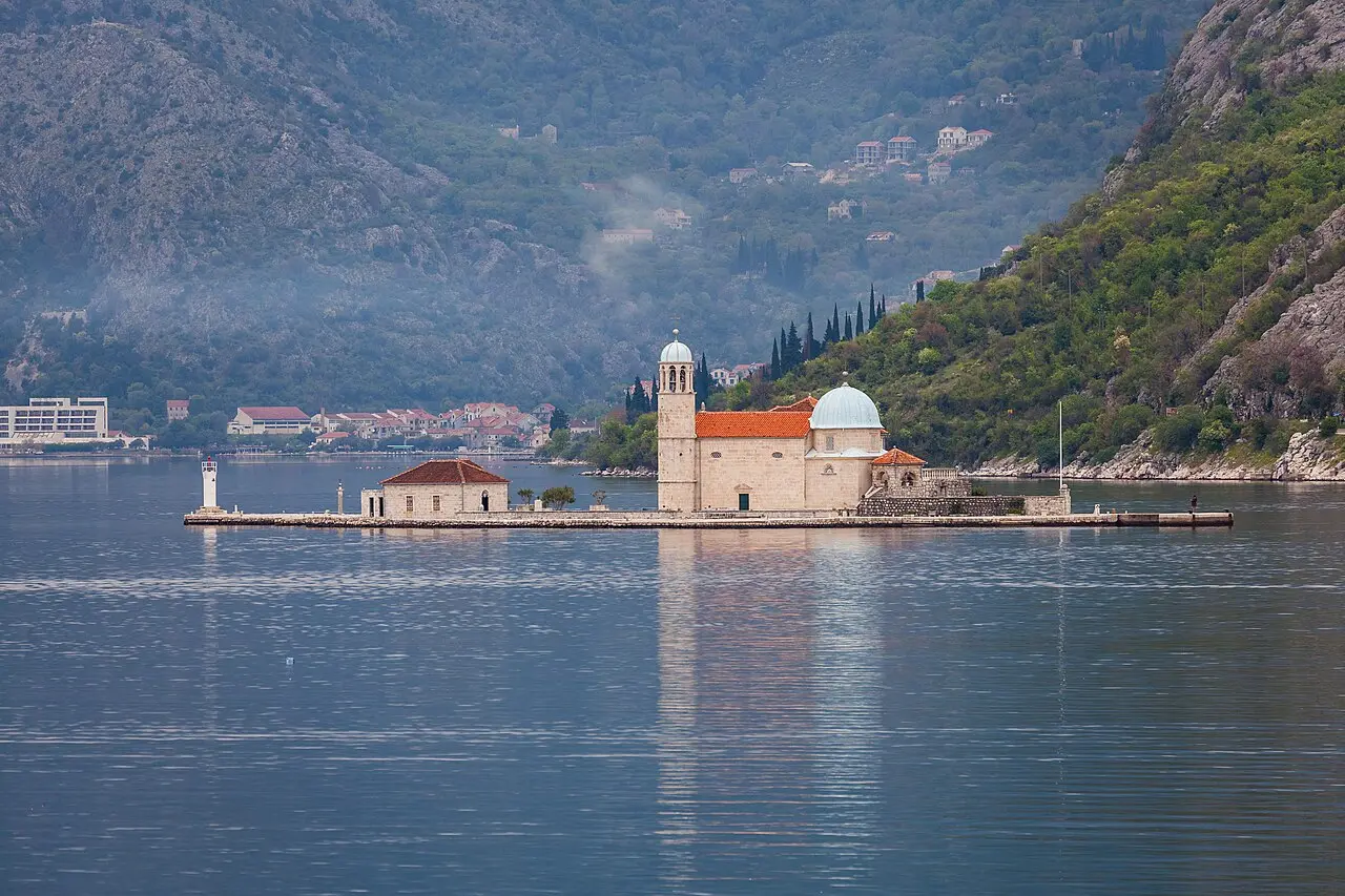 The island church of Our Lady of the Rocks sitting on the water in the Bay of Kotor near Perast