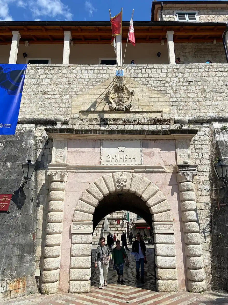 The arched Sea Gate, the main western entrance into Kotor Old Town, with flags above