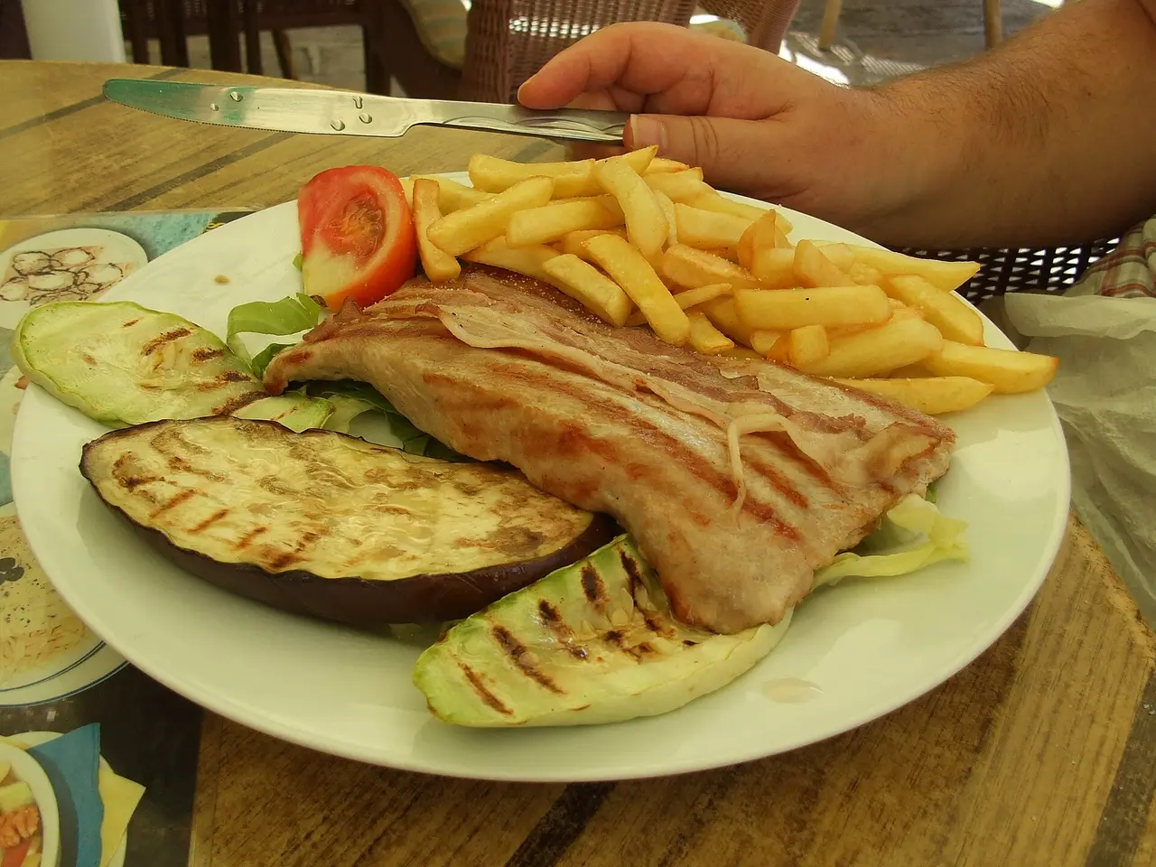 A Njeguški steak of veal with cured ham, served with chips and grilled vegetables in Budva, Montenegro