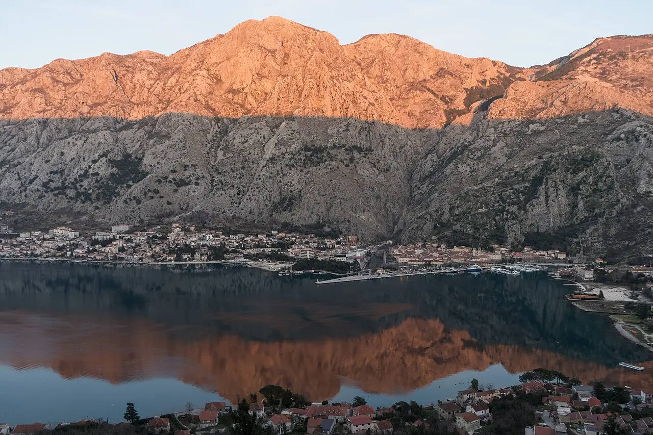 Kotor at sunset, glowing mountains reflected in the still waters of the Bay of Kotor