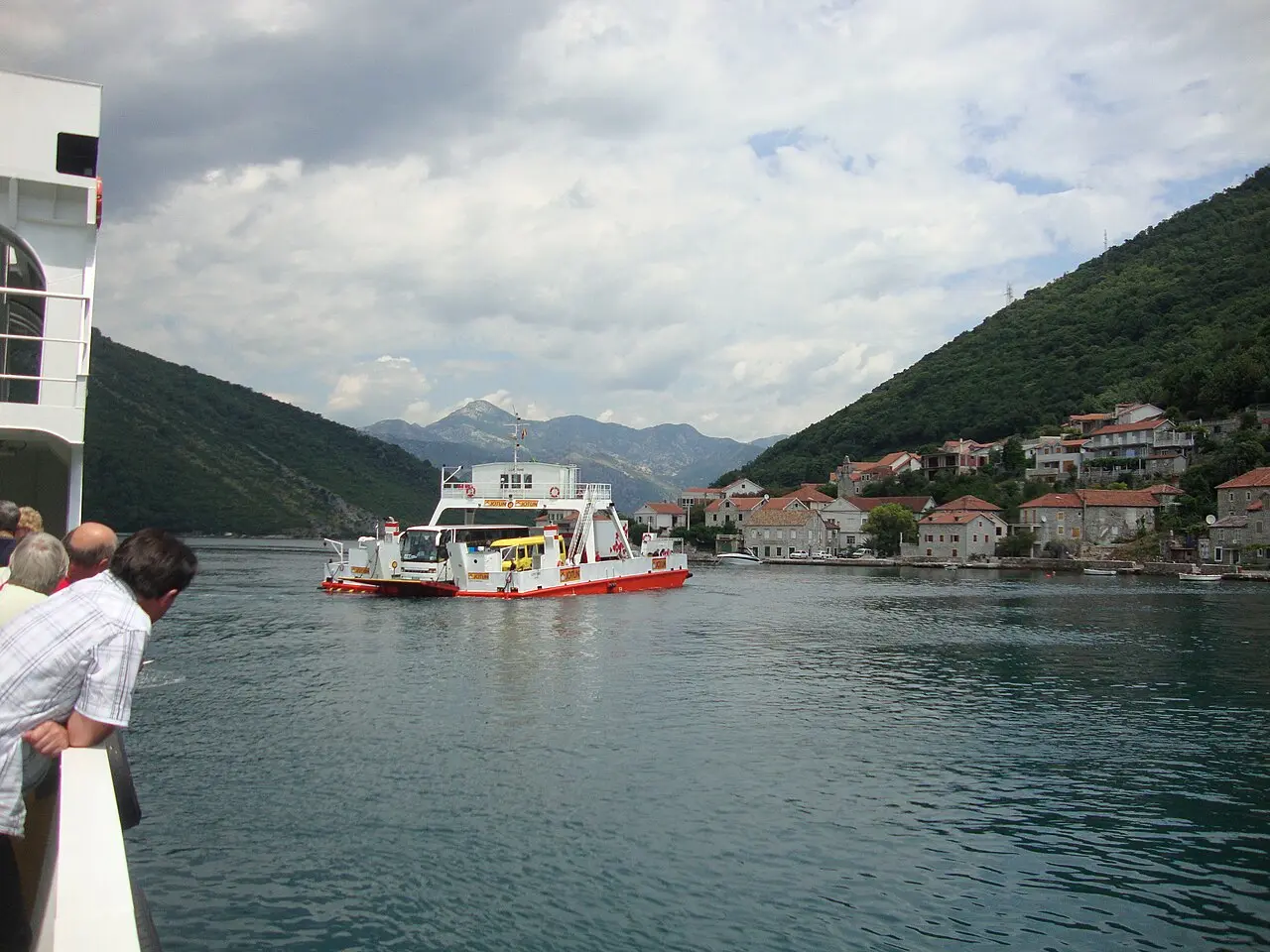 The Kamenari to Lepetane car ferry crossing the Bay of Kotor with the village of Lepetane behind