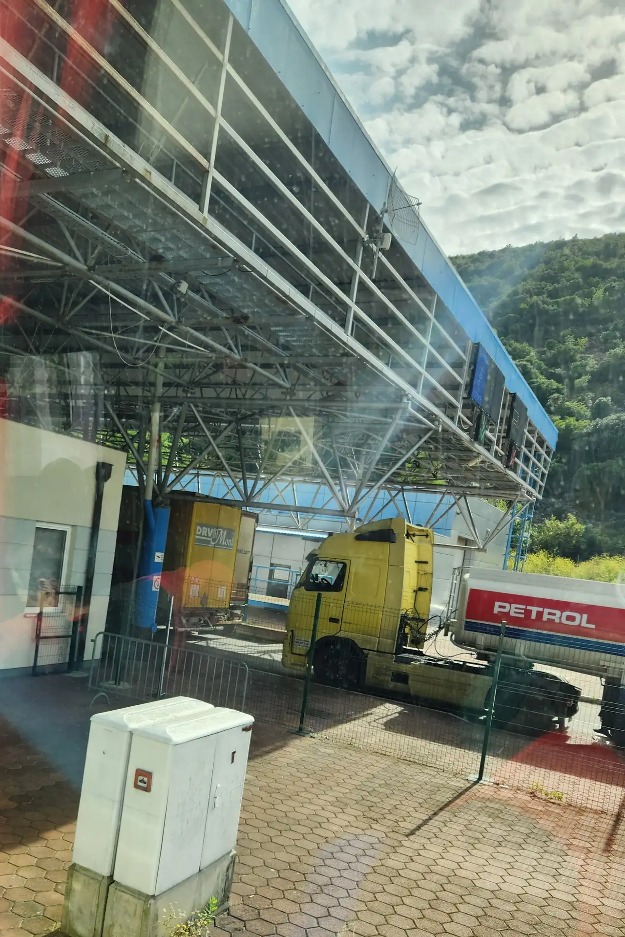 Truck lanes under the steel canopy of the Croatia-Montenegro border crossing with a lorry waiting at the control booths