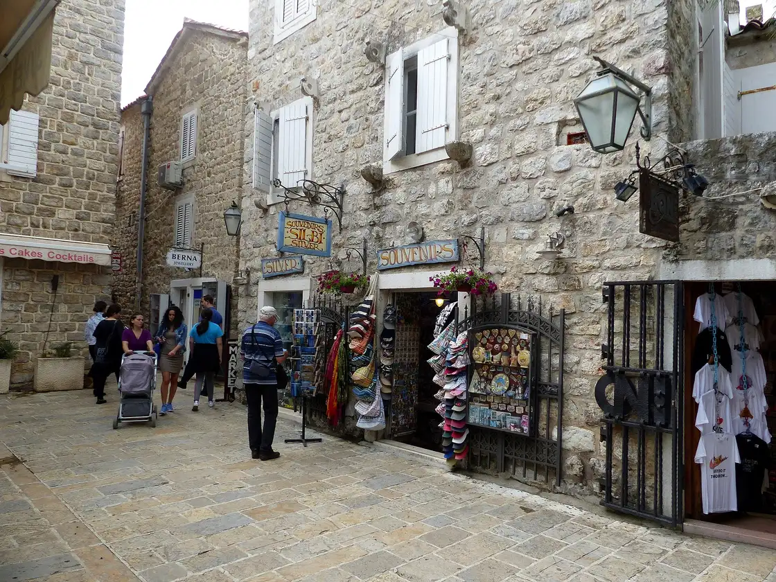 Shoppers on a stone lane of Budva Old Town lined with jewellery and souvenir shops