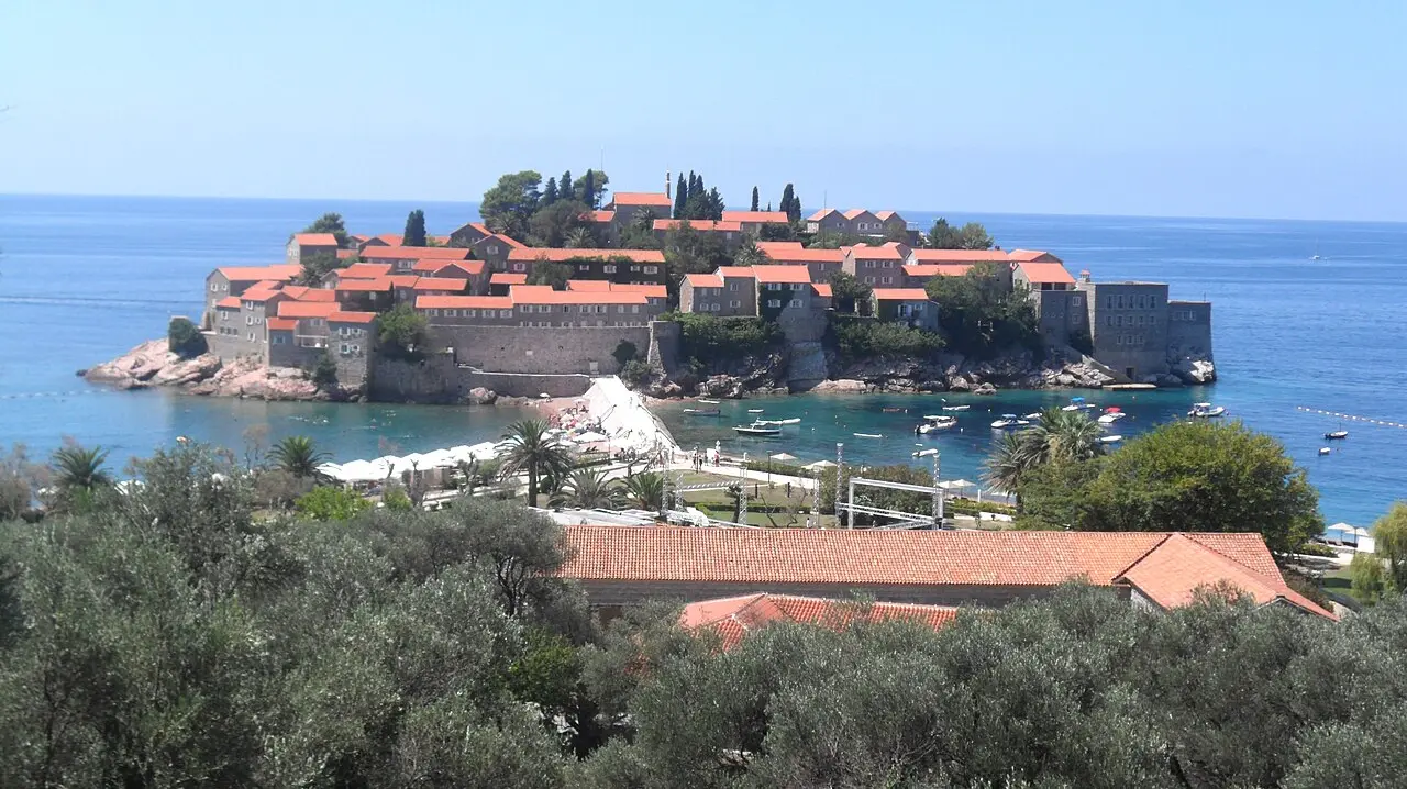 The islet of Sveti Stefan and its terracotta roofs off the Budva Riviera, Montenegro, in clear late-summer weather