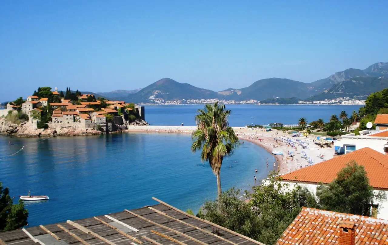 The Budva Riviera coastline with a beach, the Sveti Stefan islet and mountains behind, Montenegro