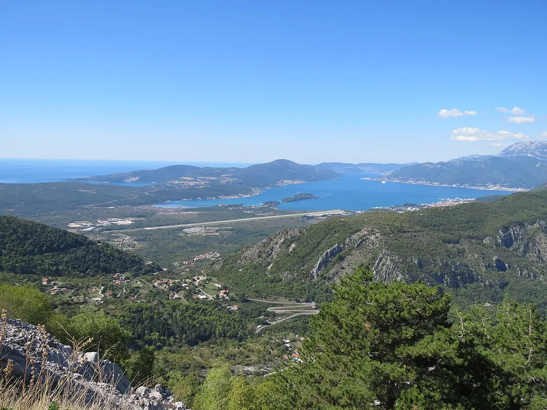 Tivat Airport runway beside the bay, with mountains across the water