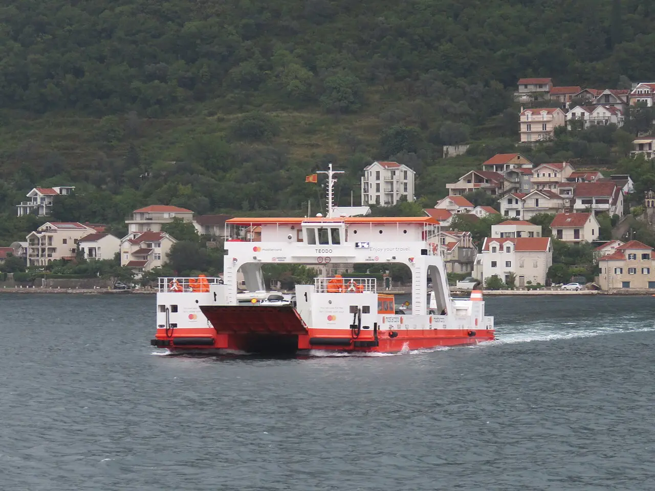 The Kamenari-Lepetane car ferry crossing the Bay of Kotor with waterfront houses behind it