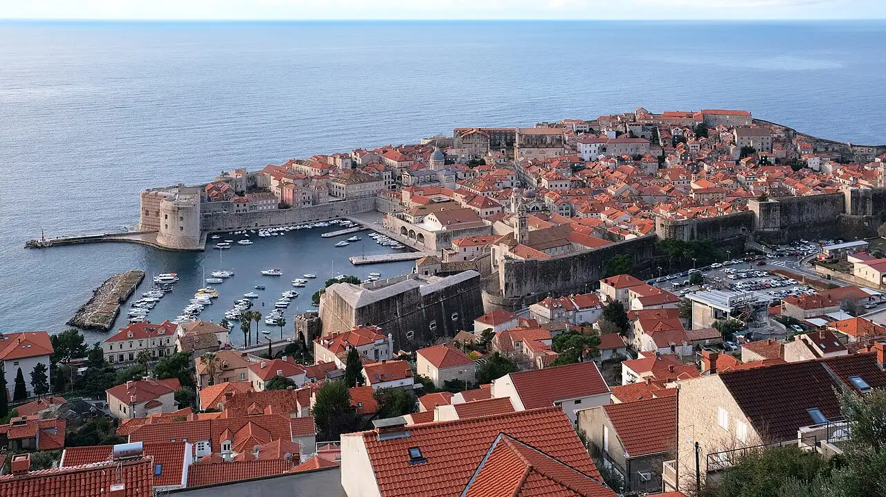 The red rooftops and sea walls of Dubrovnik Old Town seen from the city walls, with the Adriatic beyond