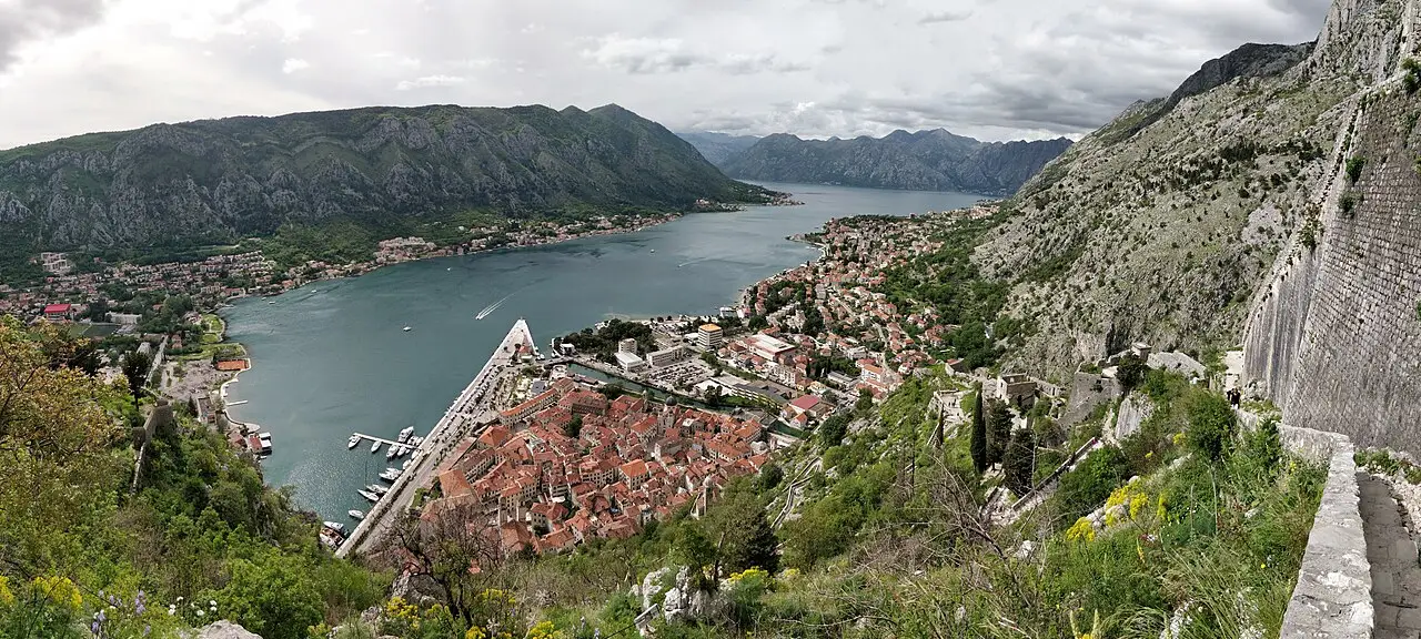 Panorama of Kotor and its bay from above, the old town at the water's edge ringed by steep mountains