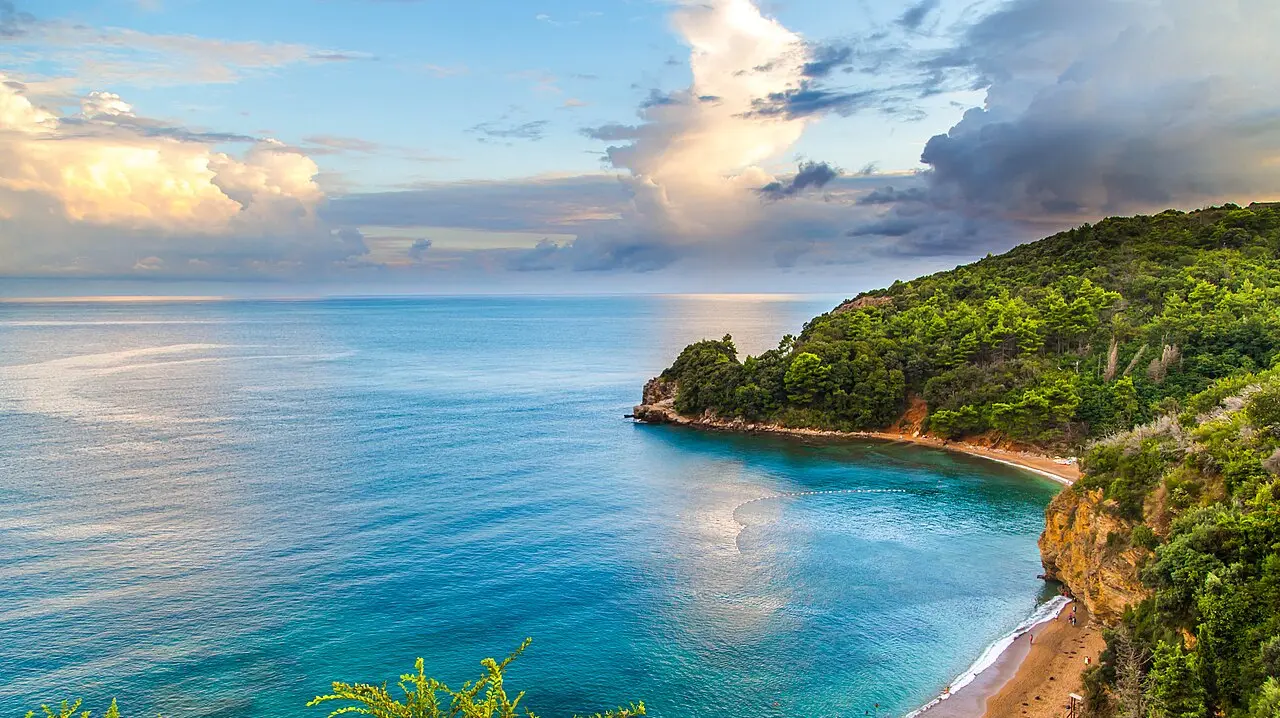 A turquoise cove and green headland on the Budva Riviera at sunset, Montenegro
