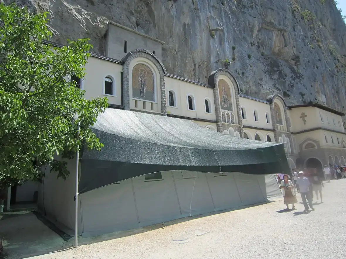 The white painted façade and arcades of the Upper Monastery at Ostrog with visitors