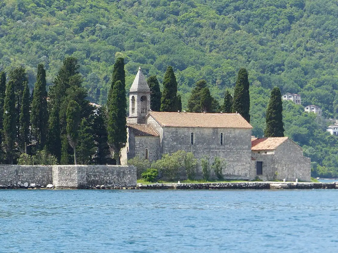 The natural island of St George near Perast with its stone abbey ringed by tall cypress trees